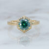 yellow-gold-hexagon-halo-engagement-ring-with-teal-blue-green-mossianite-center-stone-with-a-simple-band